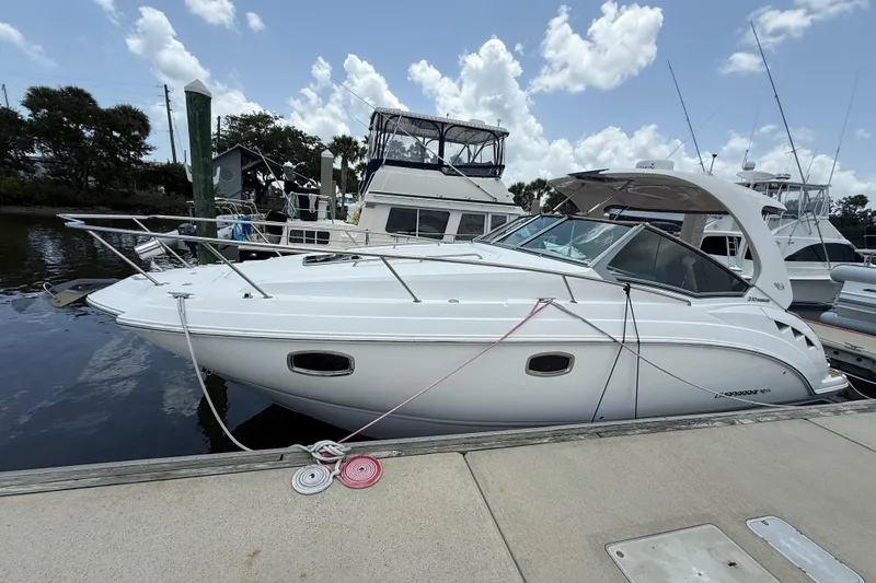 The Image of 2011 Chaparral 310 Signature boat docked at marina under blue sky. - 0