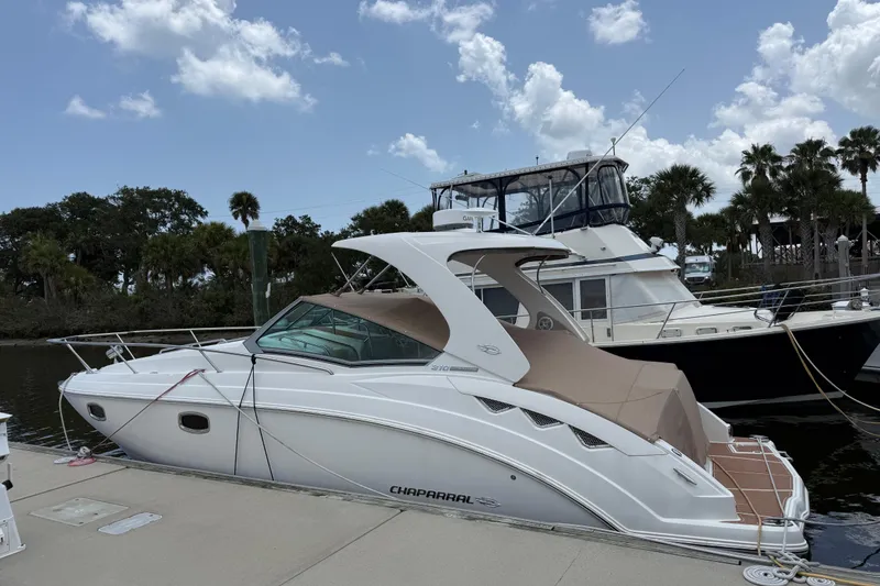 Slide: The Image of 2011 Chaparral 310 Signature boat docked at marina under blue sky. - 2