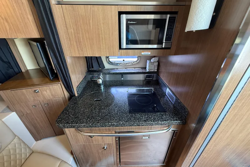 Slide: The Image of Compact kitchen in 2011 Chaparral 310 Signature boat with microwave and stovetop. - 37
