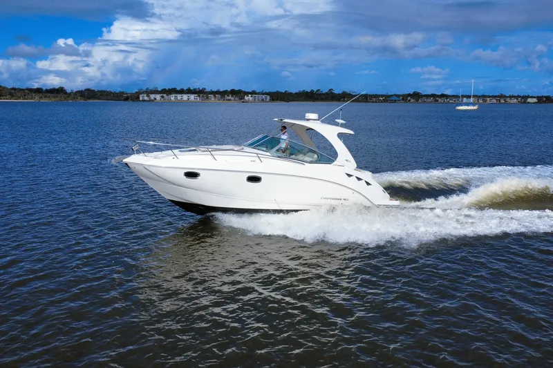 Slide: The Image of 2011 Chaparral 310 Signature cruising on a serene lake under a partly cloudy sky. - 1