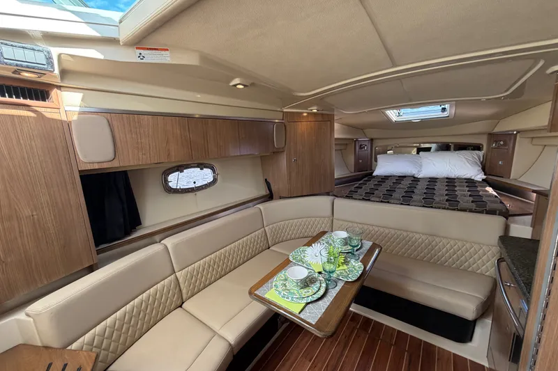 Slide: The Image of 2011 Chaparral 310 Signature cabin interior with seating, table, and bed. - 17