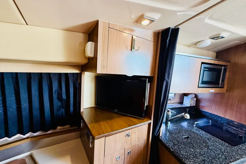 Slide: The Image of 2011 Chaparral 310 Signature interior with kitchenette, microwave, and TV. - 36
