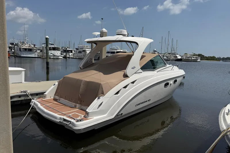 Slide: The Image of 2011 Chaparral 310 Signature boat docked at marina under clear sky. - 4
