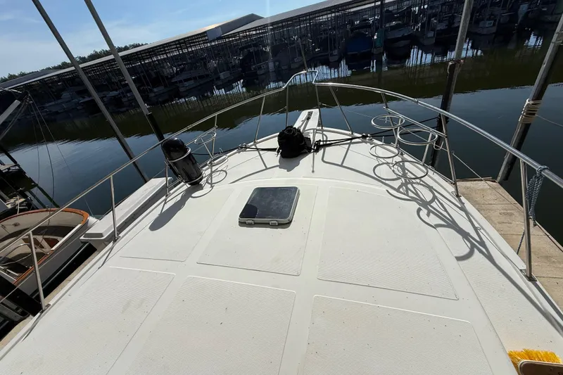 Slide: The Image of 1989 Heritage East 40 yacht deck view at marina, showcasing spacious layout and railing. - 10