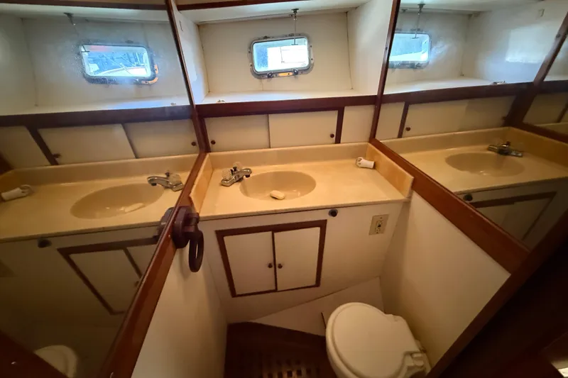 Slide: The Image of 1989 Heritage East 40 yacht bathroom with sink, mirror, and porthole window. - 25