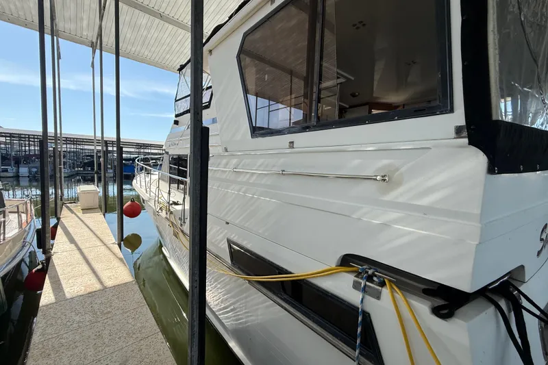 Slide: The Image of 1989 Heritage East 40 yacht docked at marina, side view with reflections on water. - 7