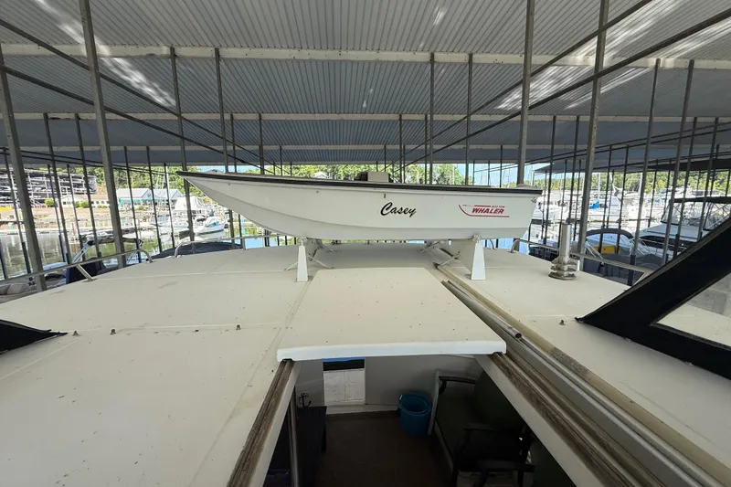 Slide: The Image of 1989 Heritage East 40 boat with a small dinghy on top, docked in a marina. - 14