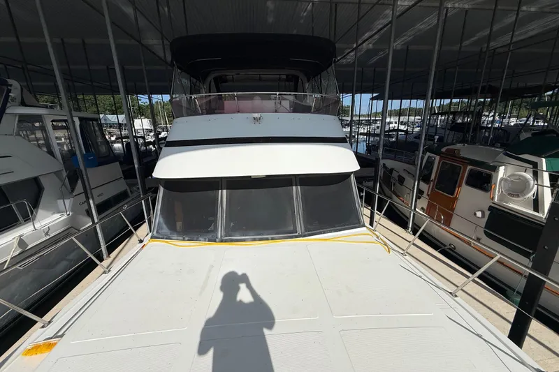 Slide: The Image of 1989 Heritage East 40 yacht docked in a marina, surrounded by other boats. - 13