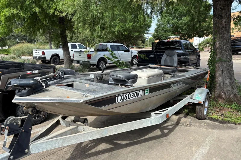 Slide: The Image of 2011 Tracker Panfish 16 boat on trailer, parked outdoors near trees and vehicles. - 3