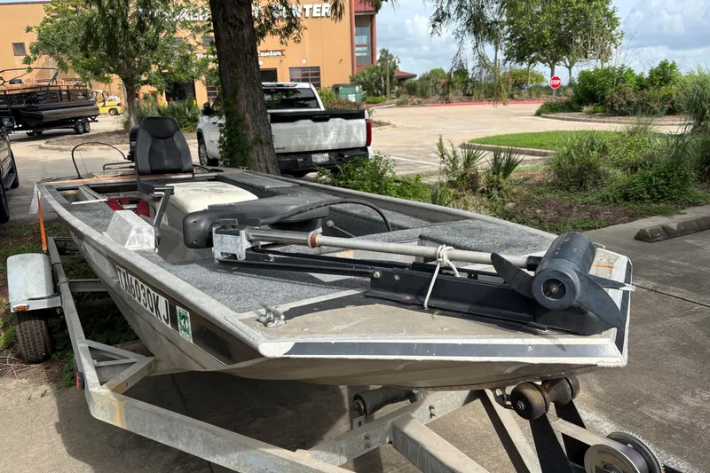 Slide: The Image of 2011 Tracker Panfish 16 boat on trailer, parked outdoors near trees and a building. - 4