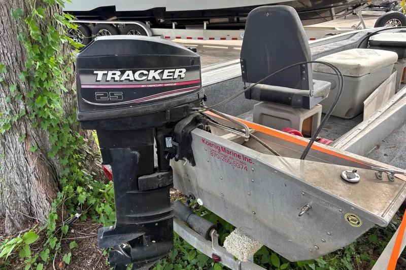Slide: The Image of 2011 Tracker Panfish 16 boat with Tracker 25 outboard motor, parked near a tree. - 6