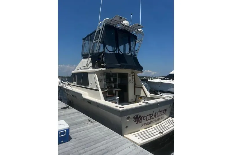 Slide: The Image of 1987 Silverton 34 Convertible yacht docked at marina under clear blue sky. - 2