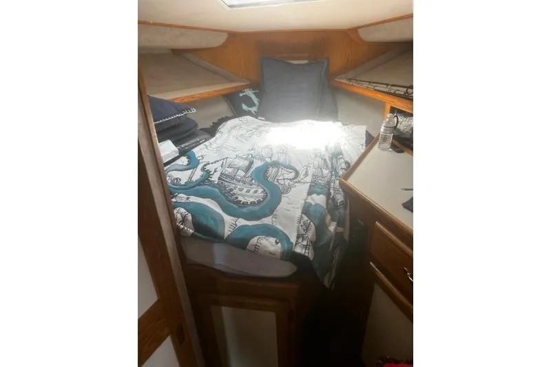 Slide: The Image of Cozy cabin interior of 1987 Silverton 34 Convertible with nautical-themed bedding. - 25