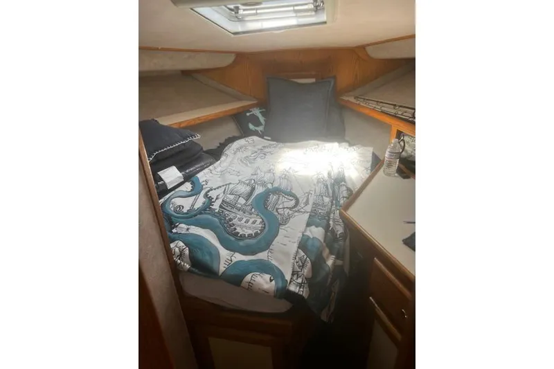 Slide: The Image of Cozy cabin interior of 1987 Silverton 34 Convertible with nautical-themed bedding. - 36