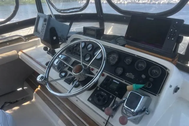 Slide: The Image of 1987 Silverton 34 Convertible boat helm with steering wheel and navigation instruments. - 6
