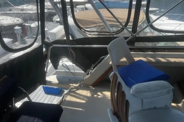Slide: The Image of 1987 Silverton 34 Convertible boat interior with seating and marina view. - 17