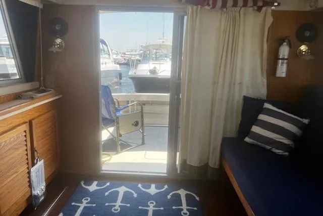 Slide: The Image of Interior view of 1987 Silverton 34 Convertible yacht with nautical decor and marina backdrop. - 31