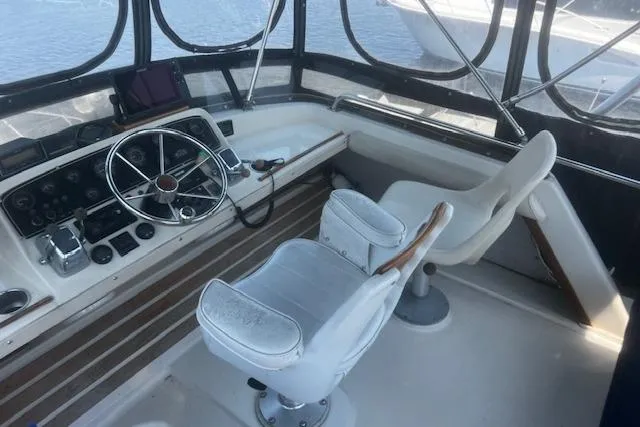 Slide: The Image of 1987 Silverton 34 Convertible boat helm with steering wheel and captain's chairs. - 8