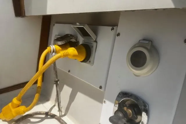 Slide: The Image of 1987 Silverton 34 Convertible boat electrical panel with yellow power cable connection. - 40