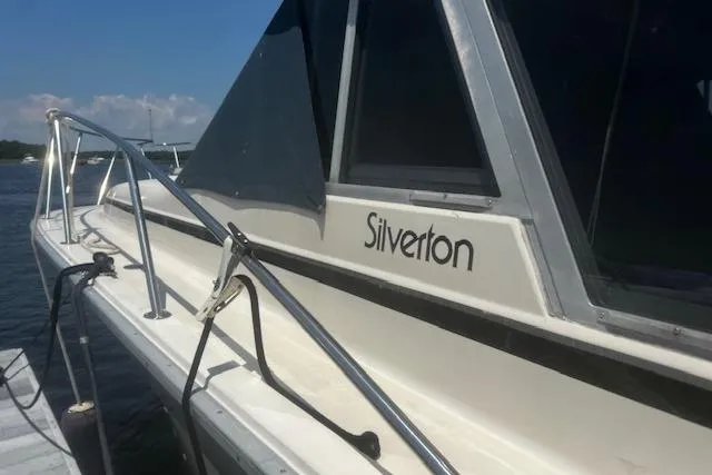 Slide: The Image of 1987 Silverton 34 Convertible boat docked, showcasing sleek design and branding. - 4