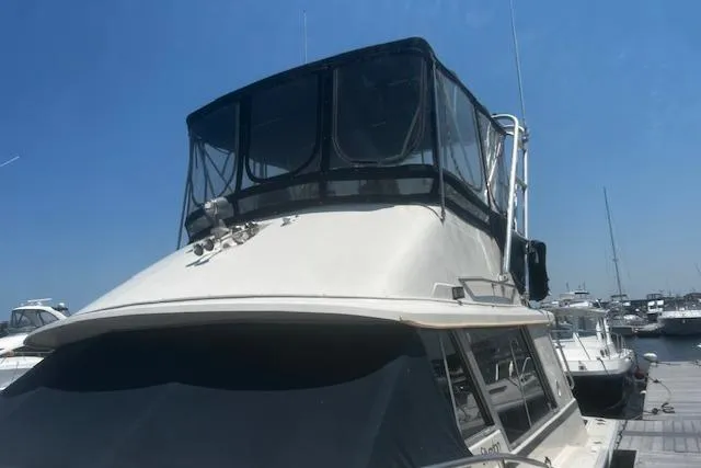 Slide: The Image of 1987 Silverton 34 Convertible boat docked at marina under clear blue sky. - 3