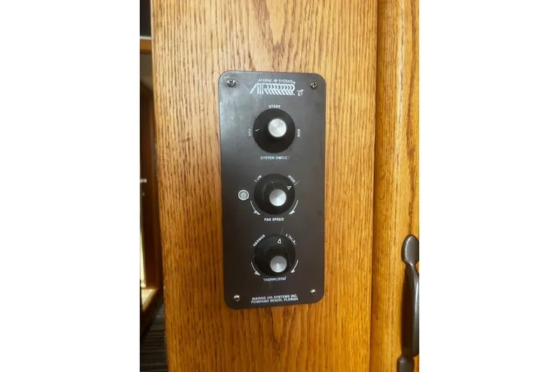 Slide: The Image of Control panel on 1987 Silverton 34 Convertible boat, featuring system switch and fan speed knobs. - 22