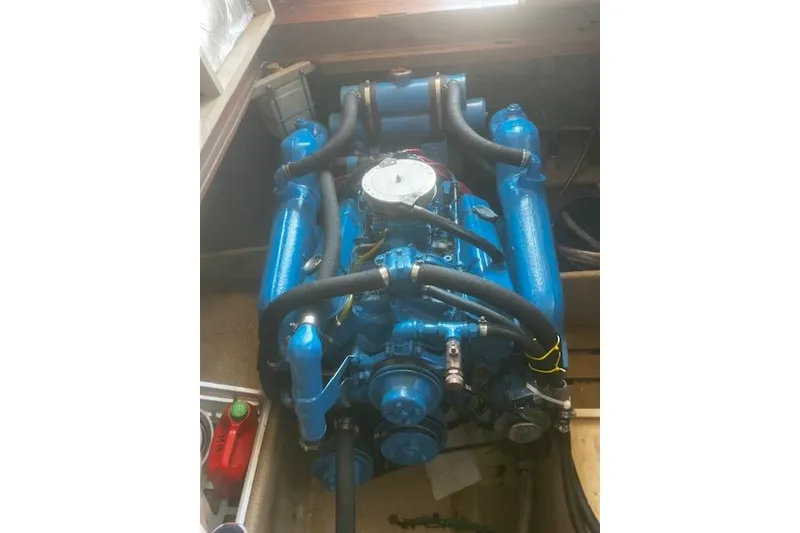 Slide: The Image of 1987 Silverton 34 Convertible engine, blue, with hoses and components visible in boat compartment. - 43