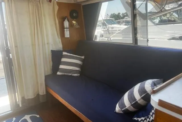 Slide: The Image of Interior of 1987 Silverton 34 Convertible with blue sofa and striped pillows. - 30