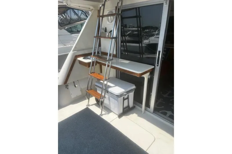 Slide: The Image of 1987 Silverton 34 Convertible yacht interior with ladder, table, and storage box. - 19