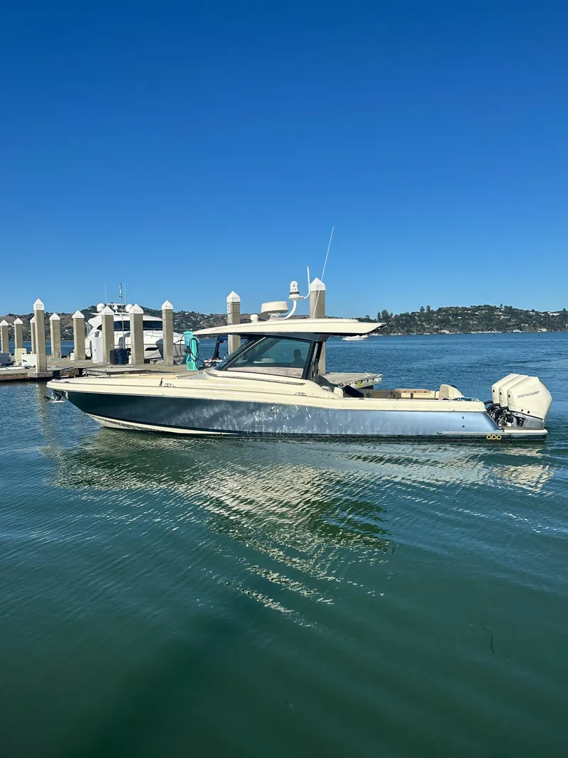 Slide: The Image of A 2023 Chris-Craft Calypso 35 boat on calm water near a dock. - 23