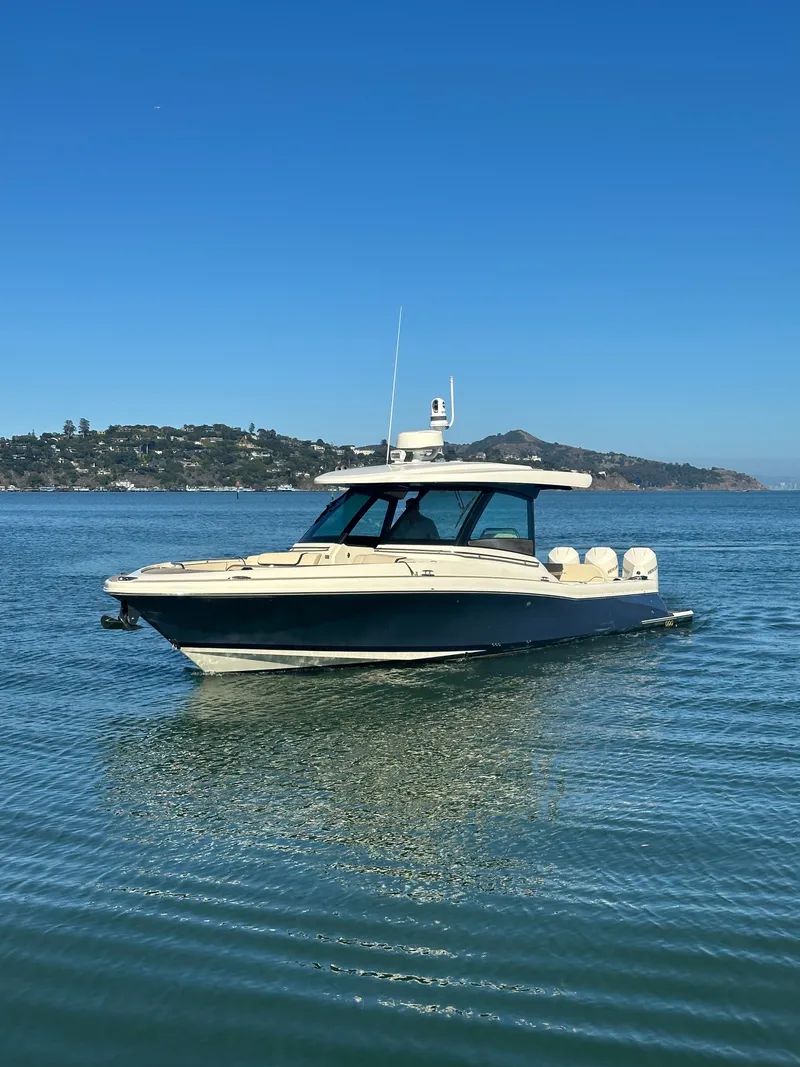 Slide: The Image of 2023 Chris-Craft Calypso 35 on calm water with a clear view of the coastline. - 19
