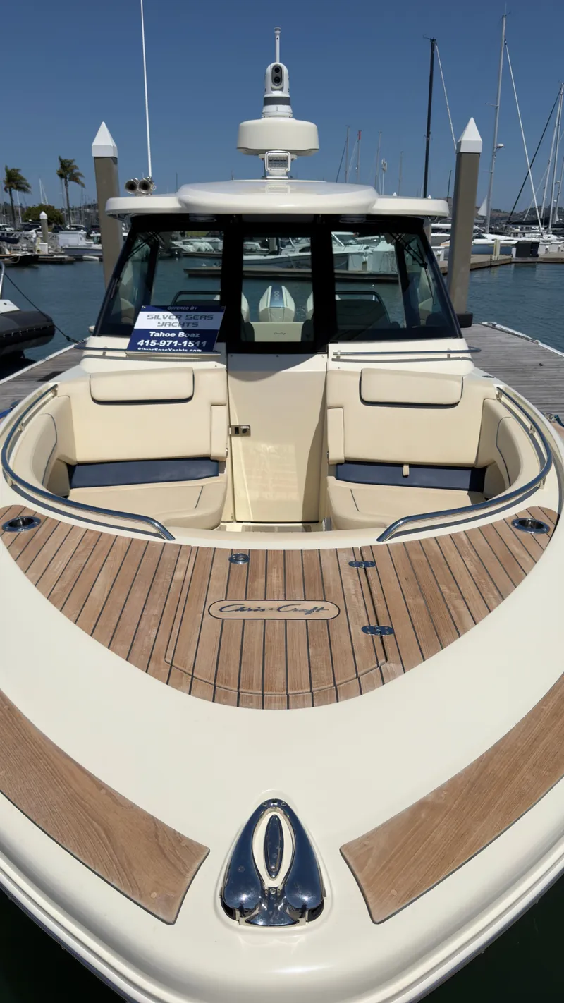 Slide: The Image of A 2023 Chris-Craft Calypso 35 docked in a marina. It features a sleek design with wooden decking. - 5