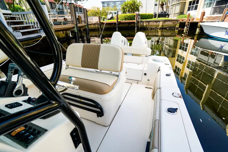 Slide: The Image of 2018 Sea Chaser 24 HFC boat interior with seating and controls, docked in a canal. - 15
