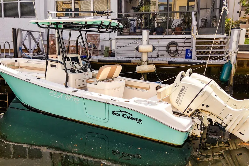 Slide: The Image of 2018 Sea Chaser 24 HFC boat docked, featuring Suzuki outboard motor. - 2