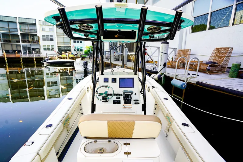 Slide: The Image of 2018 Sea Chaser 24 HFC boat docked, featuring helm and seating area. - 9