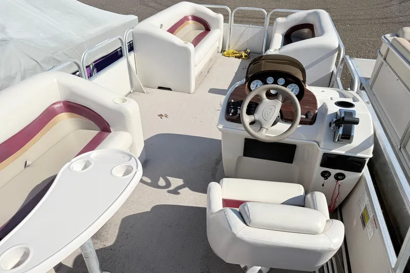 Slide: The Image of 2002 Princecraft Vantage 24 L pontoon boat interior with white seating and control console. - 12