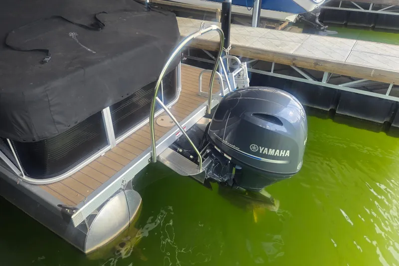 Slide: The Image of 2019 Bennington SX 22 SLX pontoon boat with Yamaha outboard motor docked on green water. - 4