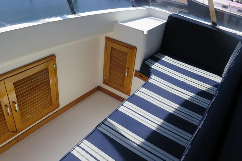 Slide: The Image of 1987 Hershine Aftcabin Motoryacht cockpit with striped seating and wooden storage cabinets. - 9