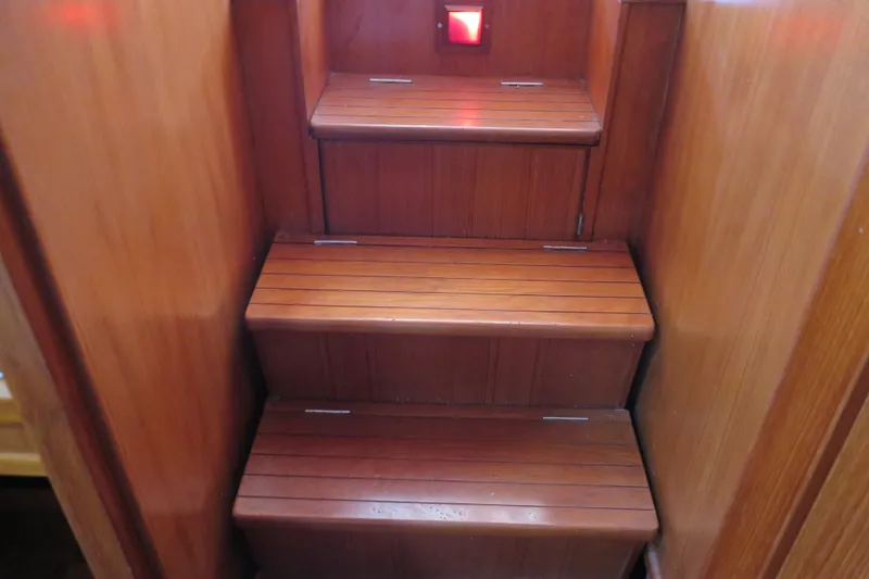 Slide: The Image of Wooden stairs inside a 1987 Hershine Aftcabin Motoryacht with Cockpit, featuring a red light. - 39