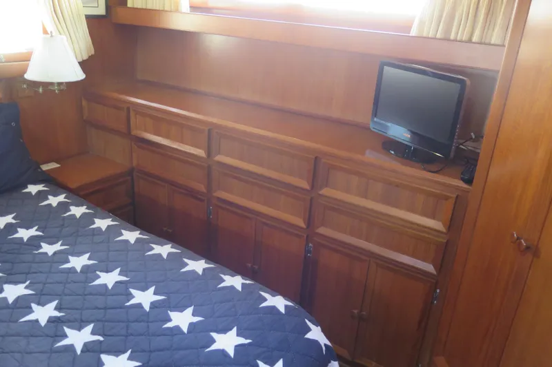 Slide: The Image of 1987 Hershine Aftcabin Motoryacht interior with wooden cabinetry and star-patterned bedding. - 34
