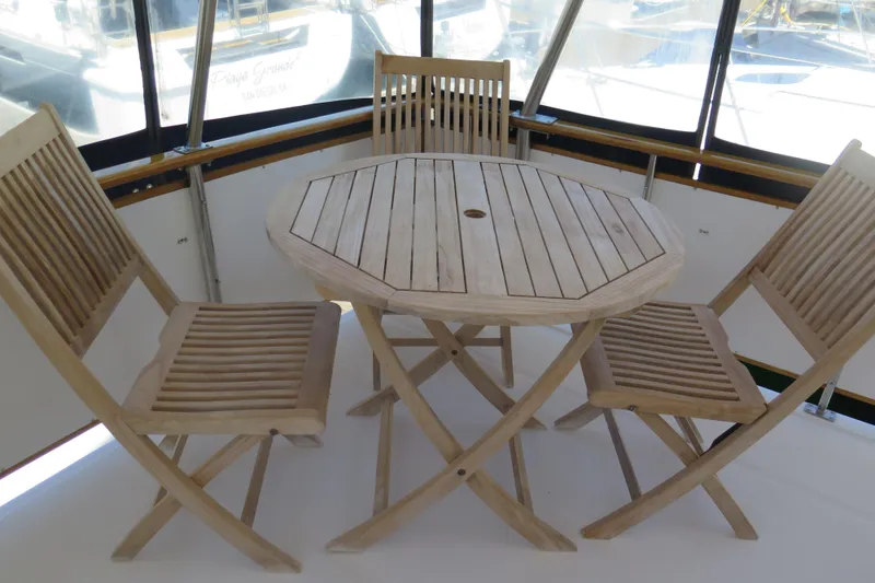 Slide: The Image of Wooden patio set on 1987 Hershine Aftcabin Motoryacht, featuring octagonal table and folding chairs. - 5