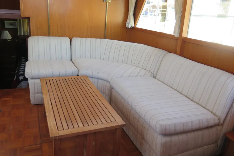 Slide: The Image of 1987 Hershine Aftcabin Motoryacht interior with striped sofa and wooden table. - 22