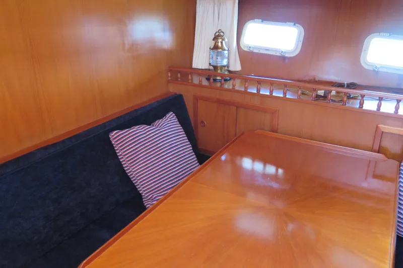 Slide: The Image of Interior of 1987 Hershine Aftcabin Motoryacht with wooden table and striped cushion. - 28