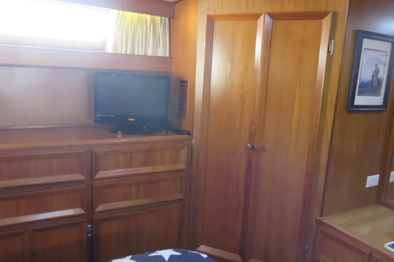 Slide: The Image of 1987 Hershine Aftcabin Motoryacht interior with wood paneling, TV, and framed artwork. - 35