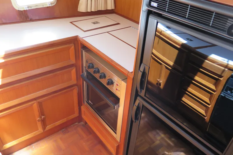 Slide: The Image of 1987 Hershine Aftcabin Motoryacht kitchen with wood cabinetry and modern appliances. - 25
