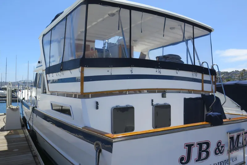 Slide: The Image of 1987 Hershine Aftcabin Motoryacht with cockpit, docked at a marina under clear blue skies. - 2