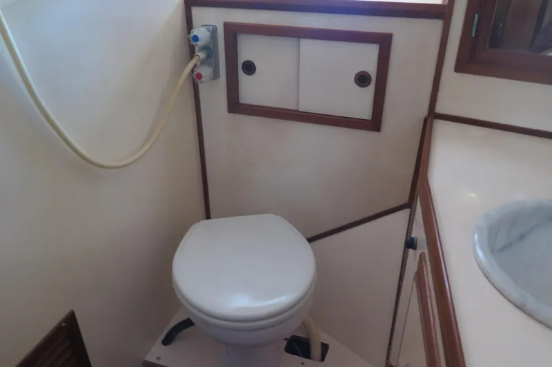 Slide: The Image of 1987 Hershine Aftcabin Motoryacht bathroom with toilet and sink. - 32