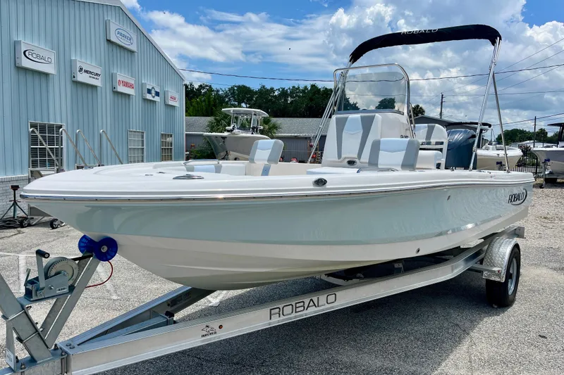 Slide: The Image of 2024 Robalo 206 Cayman boat on trailer, displayed outdoors near dealership. - 4