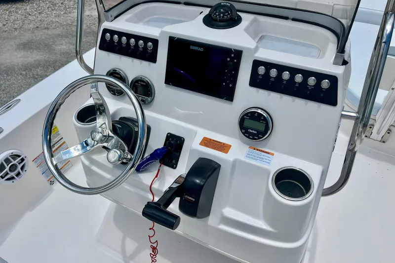 Slide: The Image of 2024 Robalo 206 Cayman boat dashboard with steering wheel and control panel. - 15