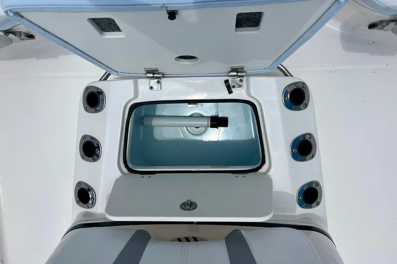 Slide: The Image of Open storage compartment on 2024 Robalo 206 Cayman boat, featuring multiple rod holders. - 19